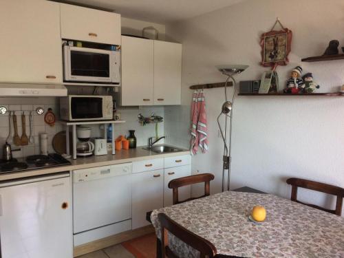 モンジェネヴルにあるChalet D'honorÉ - 2 pièces 4 pers face aux pistes MAE-7714のテーブルと電子レンジのある小さなキッチン