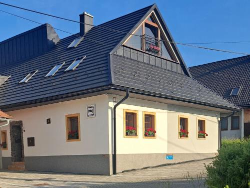 ein großes weißes Haus mit einem Walmdach in der Unterkunft Privat LeNa in Ružomberok