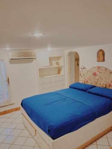 a bedroom with a bed with a blue bedspread at Pied-à-Terre in Piazzetta in Capri