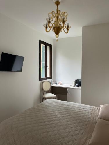 a bedroom with a bed and a chandelier at Casa sulla Laguna CASTELLO in Venice