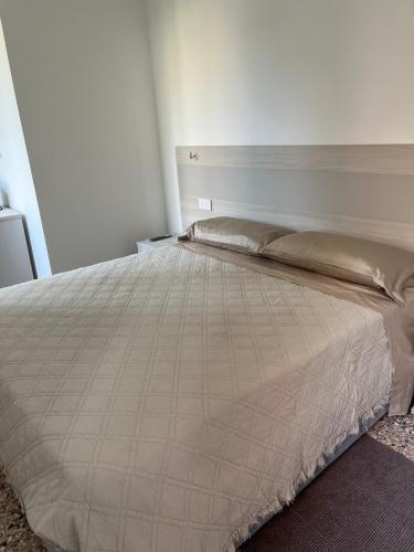a white bed in a bedroom with a white wall at Casa sulla Laguna CASTELLO in Venice