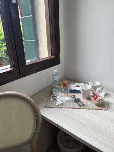 a table with cups and a bottle on top of it at Casa sulla Laguna CASTELLO in Venice