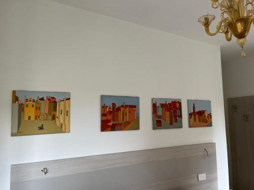 four paintings on a wall in a room at Casa sulla Laguna CASTELLO in Venice