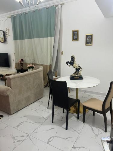 ein Wohnzimmer mit einem Tisch und einem Sofa in der Unterkunft عجمان in Sabkhah