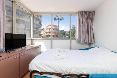 une chambre avec un lit et une grande fenêtre dans l'établissement RIO - 200 m plages - App 6pers- climatisé, terrasse, piscine, parking, à Cannes