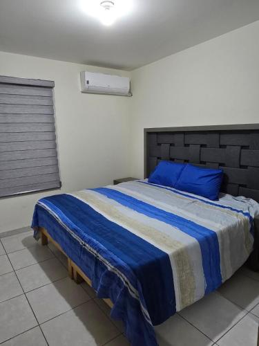 a bedroom with a large bed with blue pillows at Pozos Comfort House in San Luis Potosí