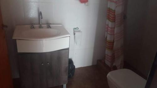 a bathroom with a sink and a toilet at El Mastil Departamentos Dormis Habitaciones in Comandante Luis Piedra Buena