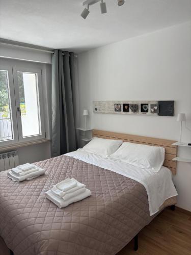 a bedroom with a large bed with two towels on it at Casa Milele in Viareggio