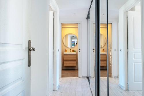 La salle de bains est pourvue de murs blancs et d'un miroir. dans l'établissement MILADY-Perle neuve, wifi, climatisée, Centre d'Antibes au calme, à Antibes
