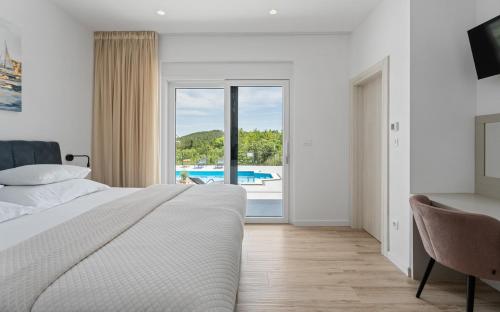 a bedroom with a bed and a view of a pool at NEW! Villa Dalmatia with Sauna, Hot tub, Heated pool in Grubine
