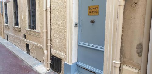 Une porte bleue sur un bâtiment avec un panneau. dans l'établissement MAT -Studio rénové clim rue piétonne du Vieil Antibes, à Antibes