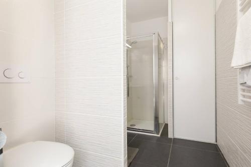 une salle de bain blanche avec toilettes et douche dans l'établissement CALYPSO- Superbe perle, Vieil Antibes, wifi, climatisation, à Antibes