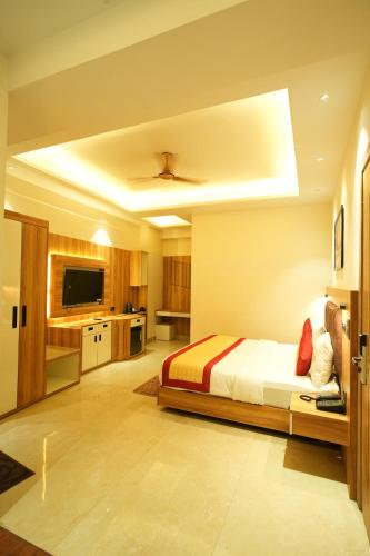 a large bedroom with a bed and a kitchen at Masaga by Qcent, Gurugram in Gurgaon