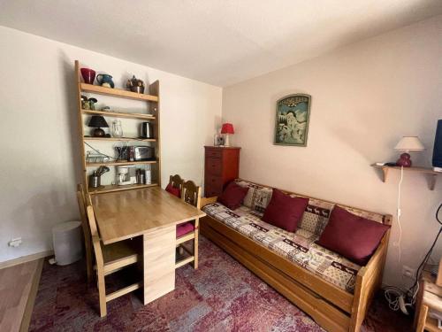 Cette chambre comprend un canapé, une table et un bureau. dans l'établissement Résidence Pluton - Studio en plein cœur de station, face aux pistes avec place de parking privée et couverte MAE-5261, à Vénosc