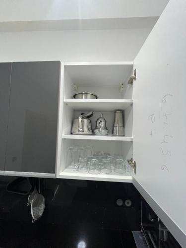 a white cupboard with pots and pans in a kitchen at Najla Sh in Tangier