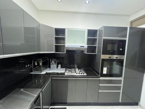 a kitchen with stainless steel appliances and black counters at Najla Sh in Tangier