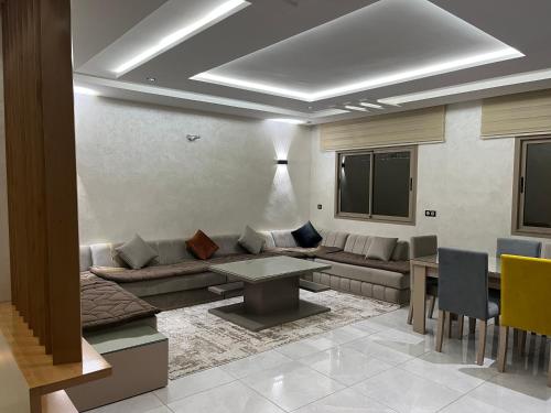 a living room with a couch and a table at Najla Sh in Tangier