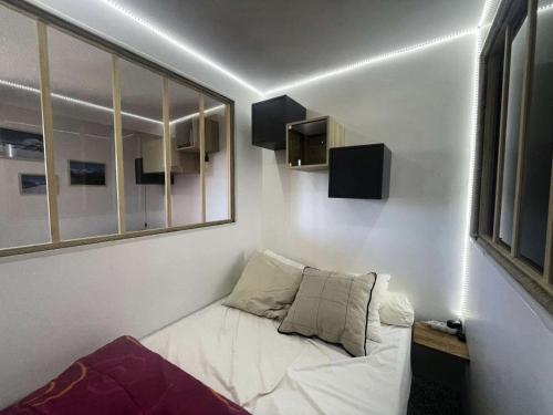 Cette petite chambre dispose d'un canapé blanc et d'une fenêtre. dans l'établissement Résidence Montana 2 - Appartement cosy avec départ ski aux pieds MAE-5581, à Vénosc