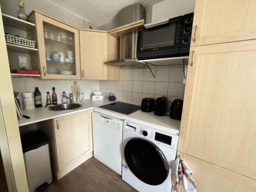 une cuisine avec une machine à laver et un évier dans l'établissement Résidence Ecrin 6 - Appartement 6 couchages avec balcons MAE-5531, à Vénosc