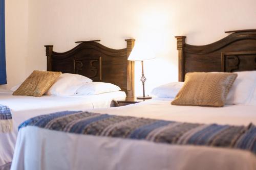 two beds sitting next to each other in a room at Hotel Las Marías in Taxisco