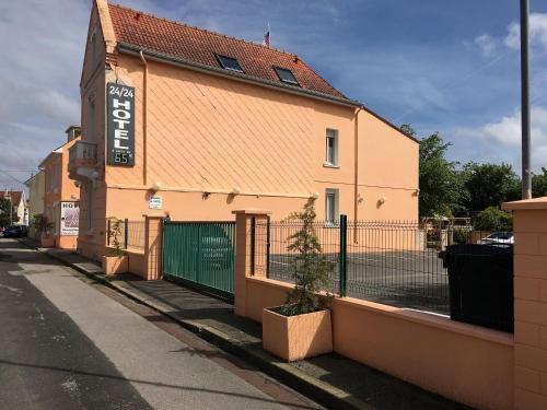 a building with a fence on the side of a street at Hôtel et Appart 'hôtel Chez Gino ETAPLES-Le Touquet in Étaples