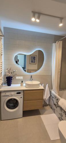 a bathroom with a sink and a washing machine at Pino 46 Sobieszewo Gdańsk in Gdańsk