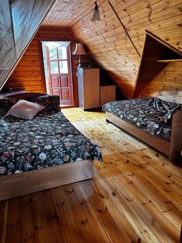 a bedroom with two beds in a log cabin at Hello Kurpie in Nowogród