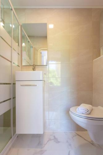 La salle de bains blanche est pourvue de toilettes et d'un escalier. dans l'établissement LYMPIA -Cosy studio, 200 m plages de Nice - Le Port, à Nice