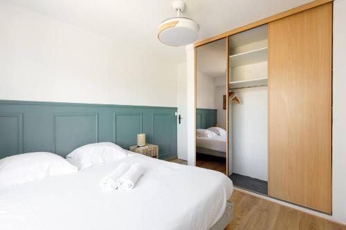 une chambre avec un grand lit blanc et un miroir dans l'établissement LE SUN-Cocon tout confort avec garage privatif, à Cagnes-sur-Mer