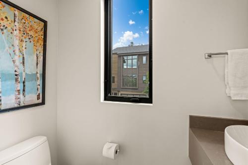 a bathroom with a window and a white toilet at 38359 Hwy 6 #14C - Basecamp in Avon