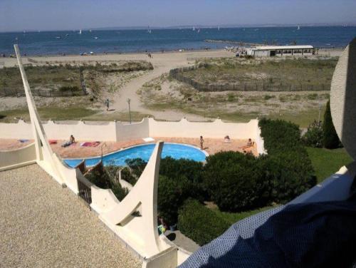 - une vue sur une piscine à côté d'une plage dans l'établissement Résidence Le Chabian - Port Camargue T2 rénové, tout équipé, en 1ère ligne mer, plage sud à 50m, piscine, tennis, climatisé MAE-7061, au Grau-du-Roi