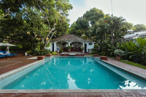 a swimming pool in front of a house at Hotel Las Marías in Taxisco