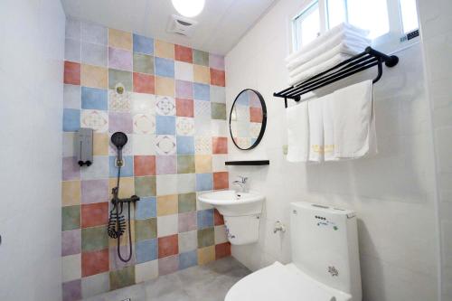 a bathroom with a toilet and a sink at Mary B&B瑪莉年代-親子友善 租車優惠 近火車站 可包棟 電動麻將 BBQ KTV in Taitung City