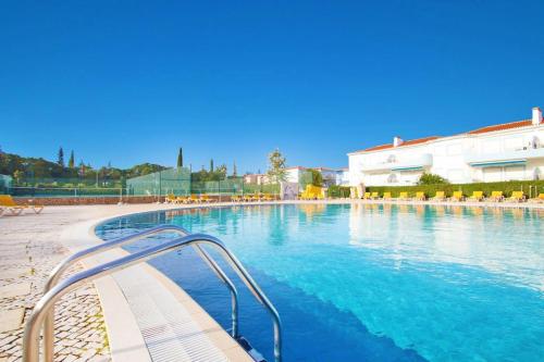 a swimming pool with blue water in a building at Casa Saudade - Oasis Parque Country Club in Portimão