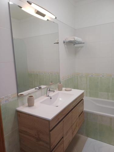 a bathroom with a sink and a mirror and a tub at Casa Saudade - Oasis Parque Country Club in Portimão