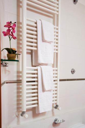a bathroom with white towels on a towel rack at Hotel Sirio in Lido di Camaiore