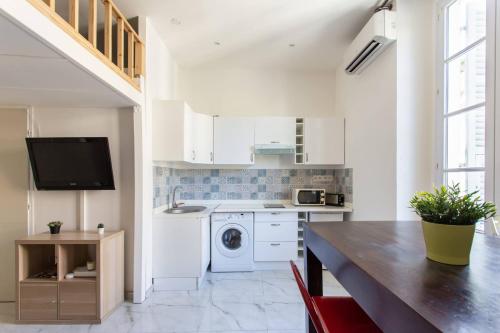 une cuisine avec des armoires blanches et une machine à laver dans l'établissement GIOA- Studio avec balcon, place Garibaldi -Paillon, à Nice