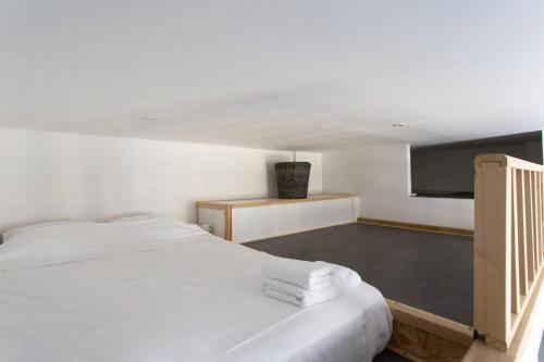 une chambre avec un lit blanc avec des serviettes dessus dans l'établissement GIOA- Studio avec balcon, place Garibaldi -Paillon, à Nice