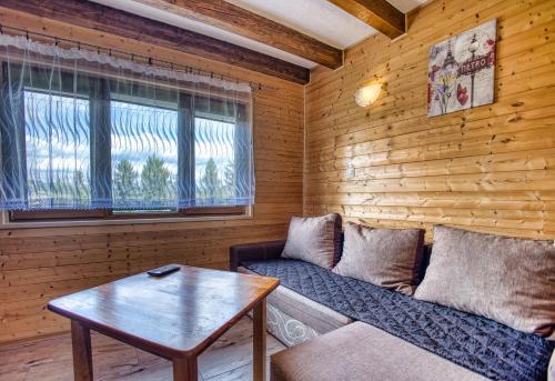 a living room with a couch and a table at Domki u Piotra in Solina