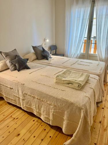 two beds in a bedroom with blue curtains at CAL QuEROL LlíViA - Piscina in Llivia