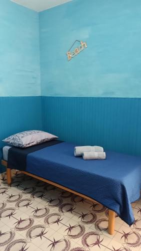 a bed in a blue room with two towels on it at LA TERRAZZA SUL MARE camera doppia vicino aereoporto&mare SICILIAN SEA STYLE ROOM in Cinisi
