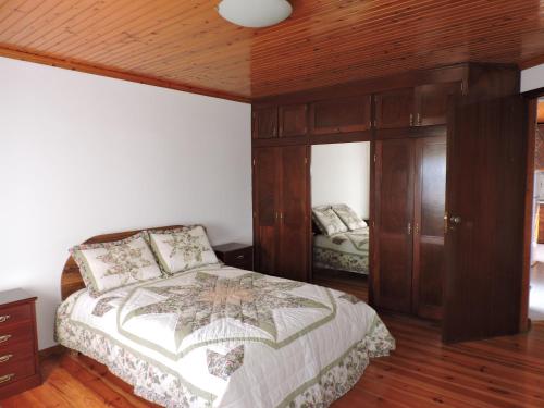 1 dormitorio con cama y techo de madera en Casas da Carlota, en São Roque do Pico