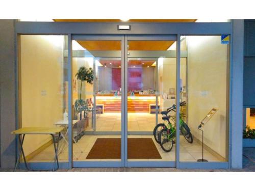 a glass door of a building with a bike inside at Smile Hotel Matsuyama - Vacation STAY 04492v in Matsuyama