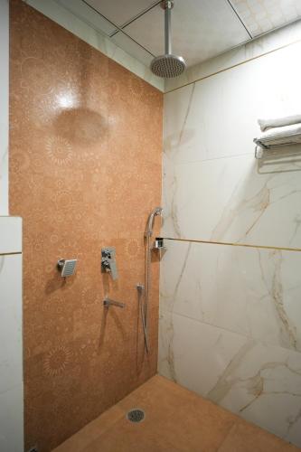 a bathroom with a shower with a glass door at Hotel MASAGA by QCENT in Gurgaon