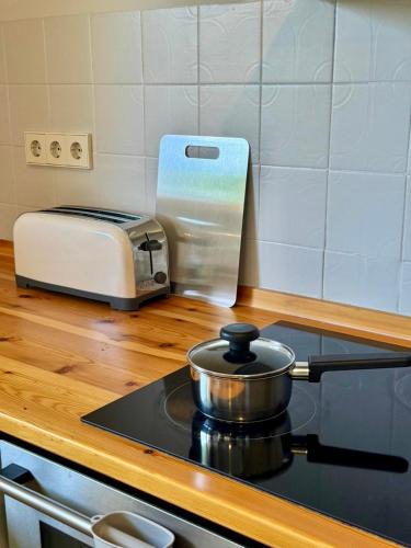 a kitchen counter with a stove and a toaster at CAL QuEROL LlíViA - Piscina in Llivia