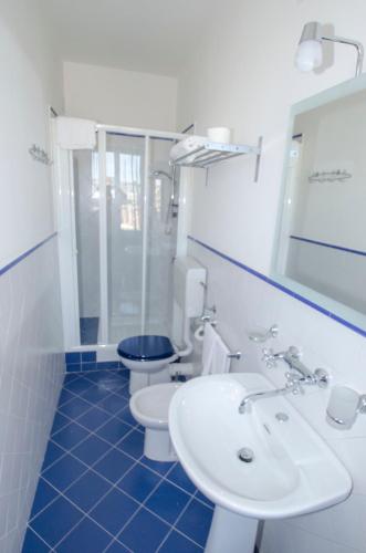 a bathroom with two toilets and a sink and a mirror at Antico Rione in Caltanissetta