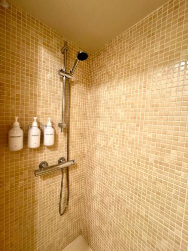 a bathroom with a shower with three white bottles at CAL QuEROL LlíViA - Piscina in Llivia