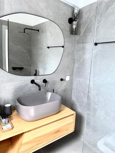 a bathroom with a sink and a mirror at PETRA Luxury Villas in Áyioi Apóstoloi