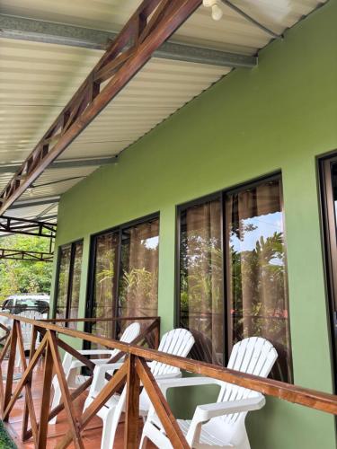 a group of white chairs sitting on a porch at OXÍGENO Río Celeste in Bijagua