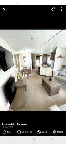 ein Wohnzimmer mit Couch und Tisch in der Unterkunft Ascot at Lochlands in Forfar